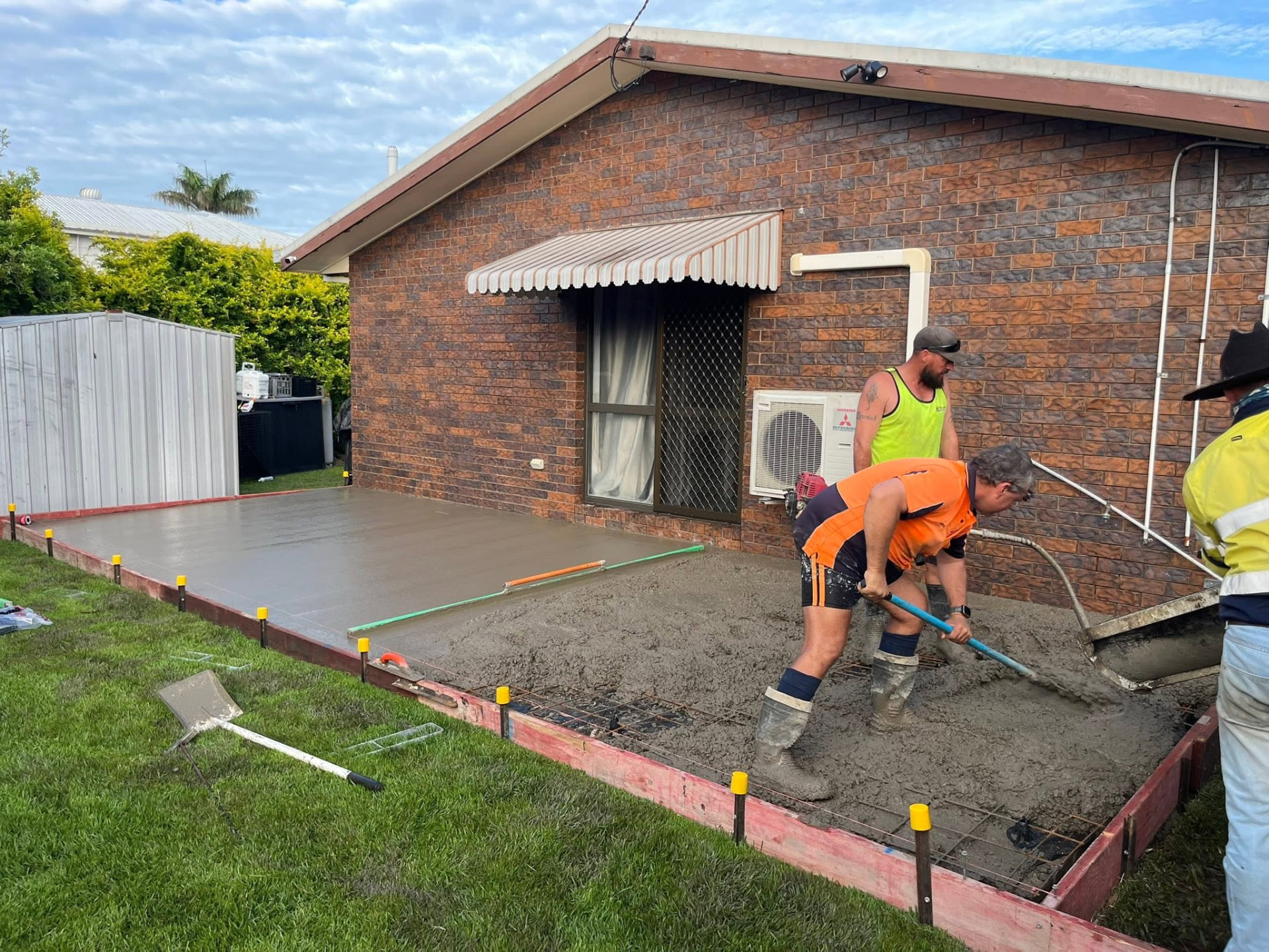 Wet concrete being screeded during a slab pour