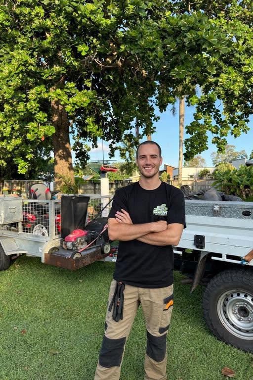 Isaac from CJM Outdoor Solutions standing in front of the work ute and mower trailer