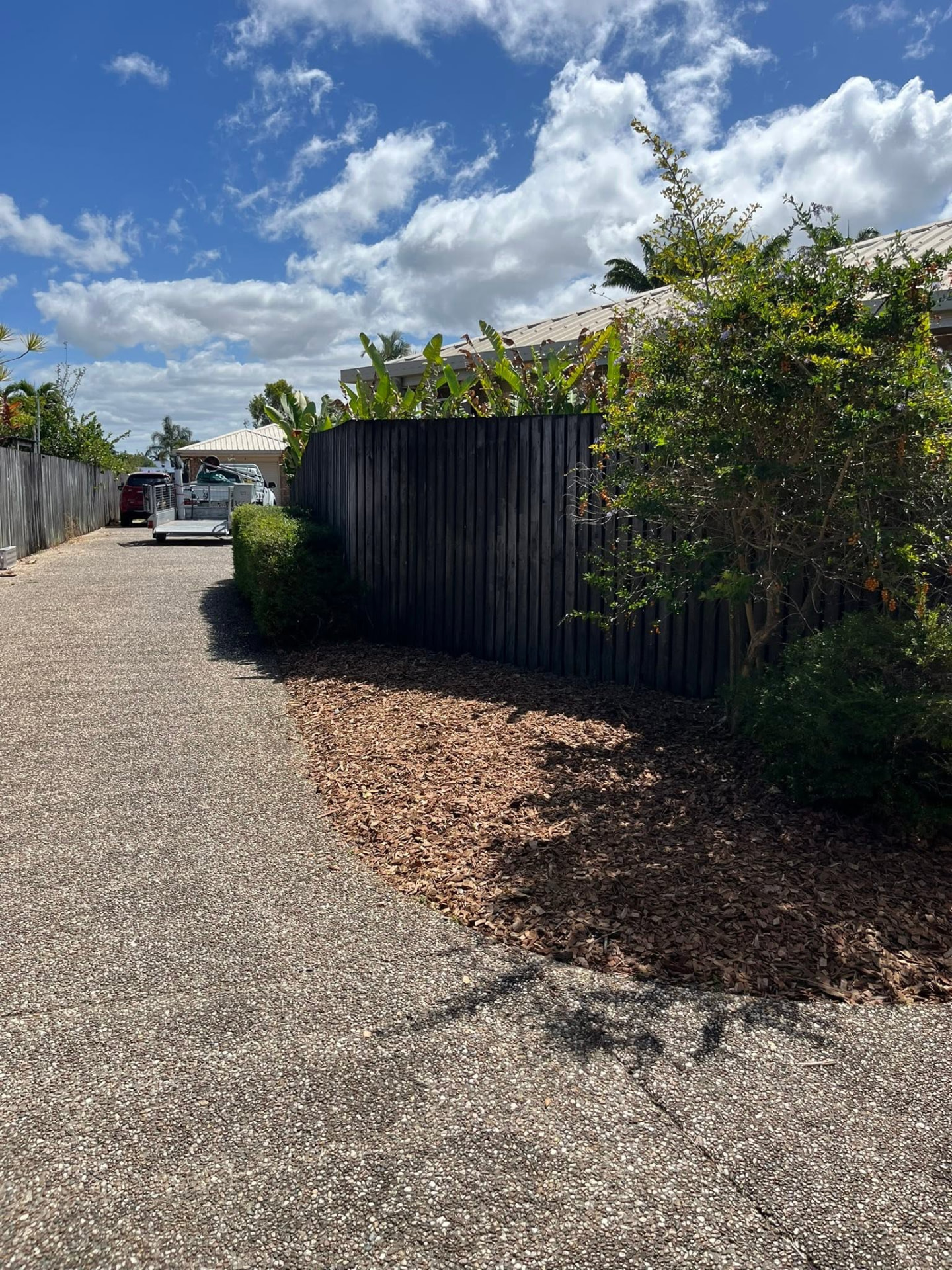 Mulched garden strip along a concrete driveway