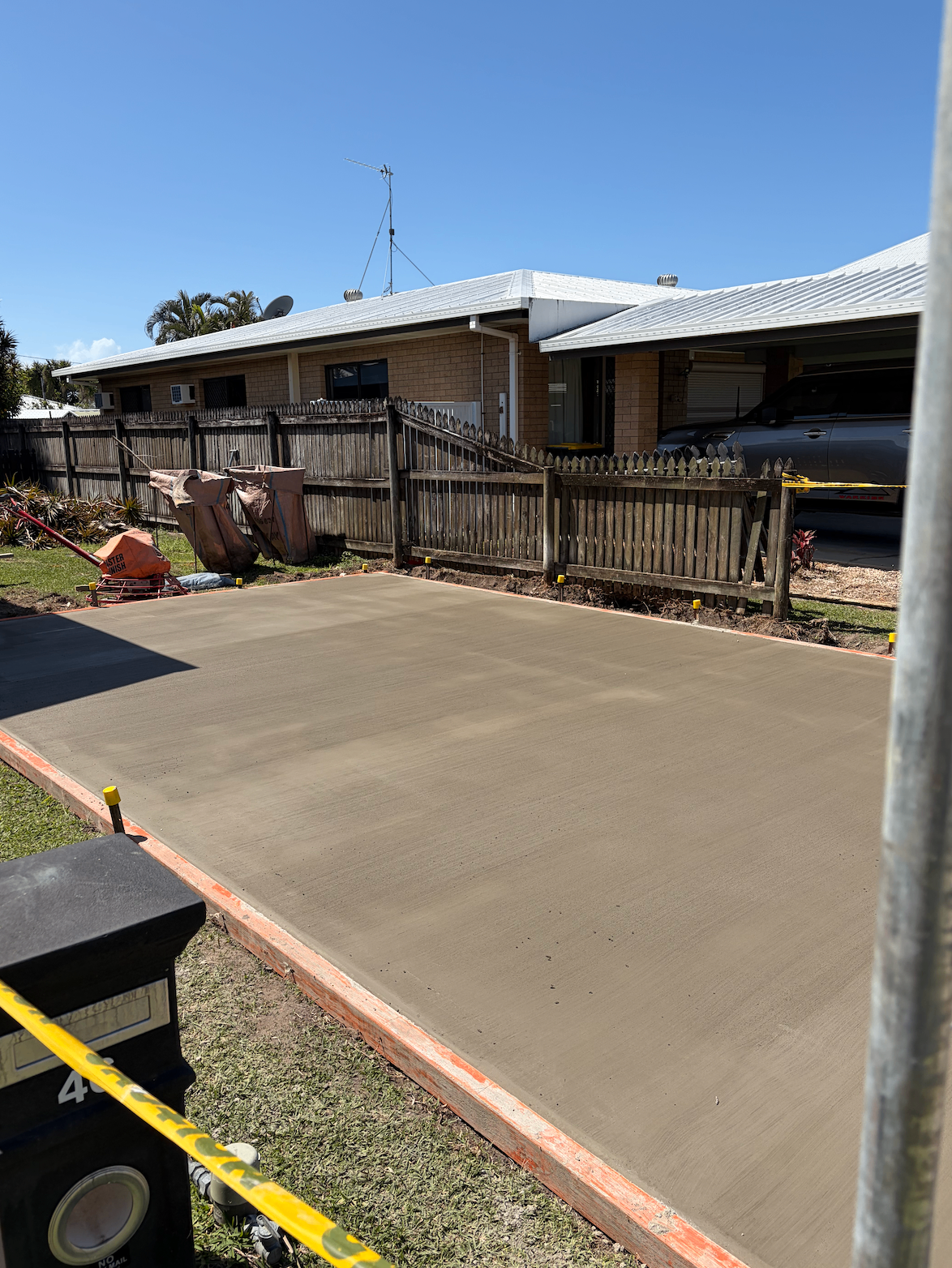 Freshly poured and finished concrete slab still in its formwork at a Mackay home